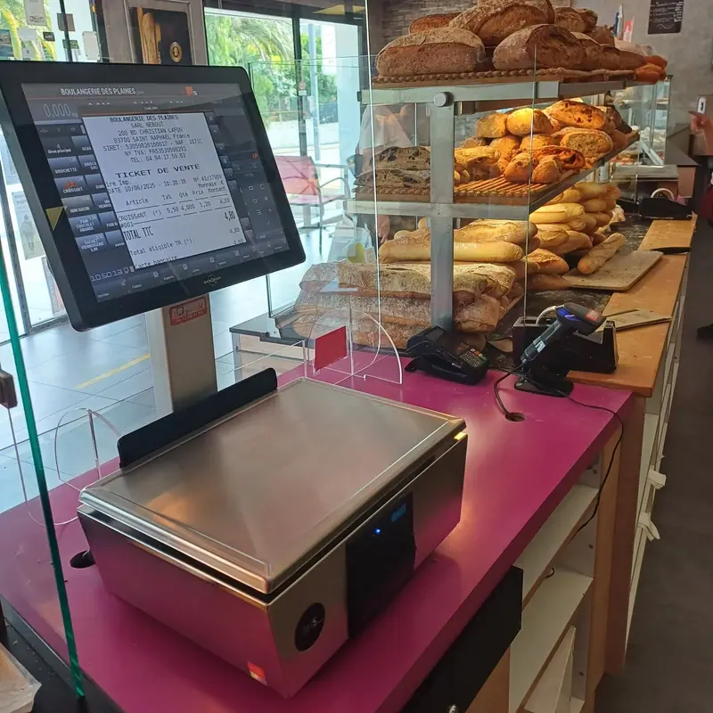 Balance poids-prix relié à l'écran de caisse sur le comptoir d'une boulangerie