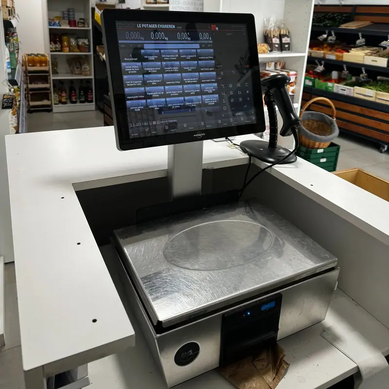 Balance poids-prix encastrée, écran de caisse et lecteur de codes-barres dans une épicerie de fruits et légumes