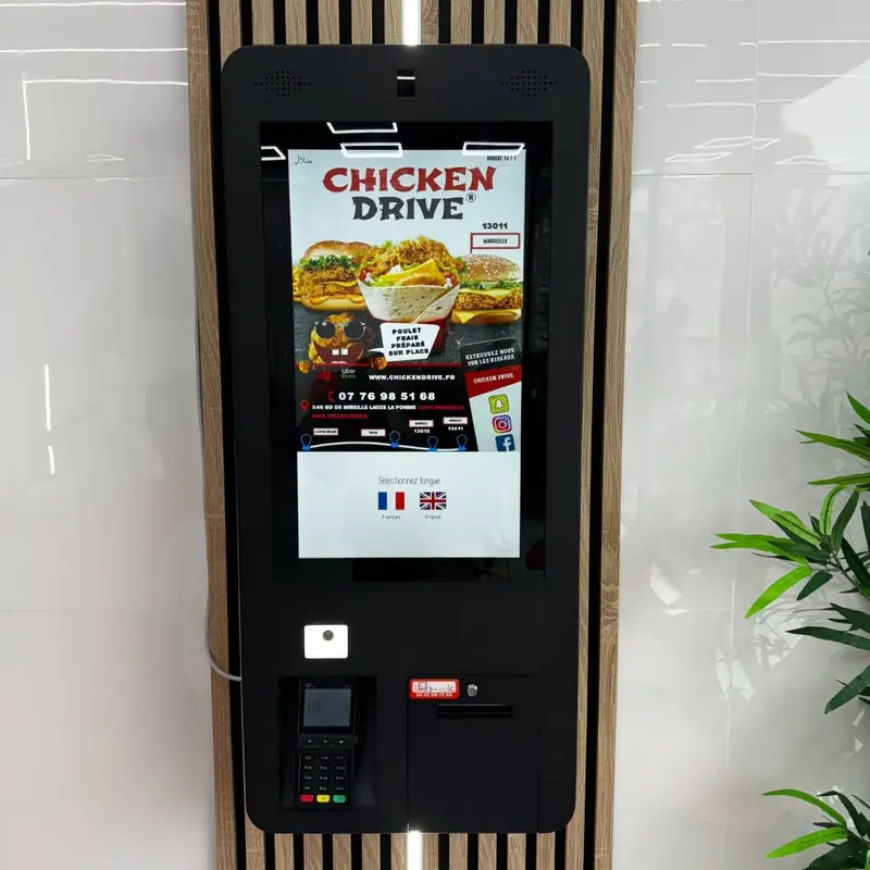 Borne de commande murale avec terminal de paiement et imprimante dans un restaurant de restauration rapide