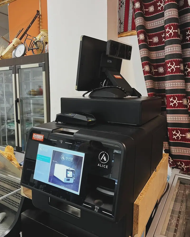 Monnayeur automatique, caisse tactile et tiroir-caisse installés dans une épicerie de quartier